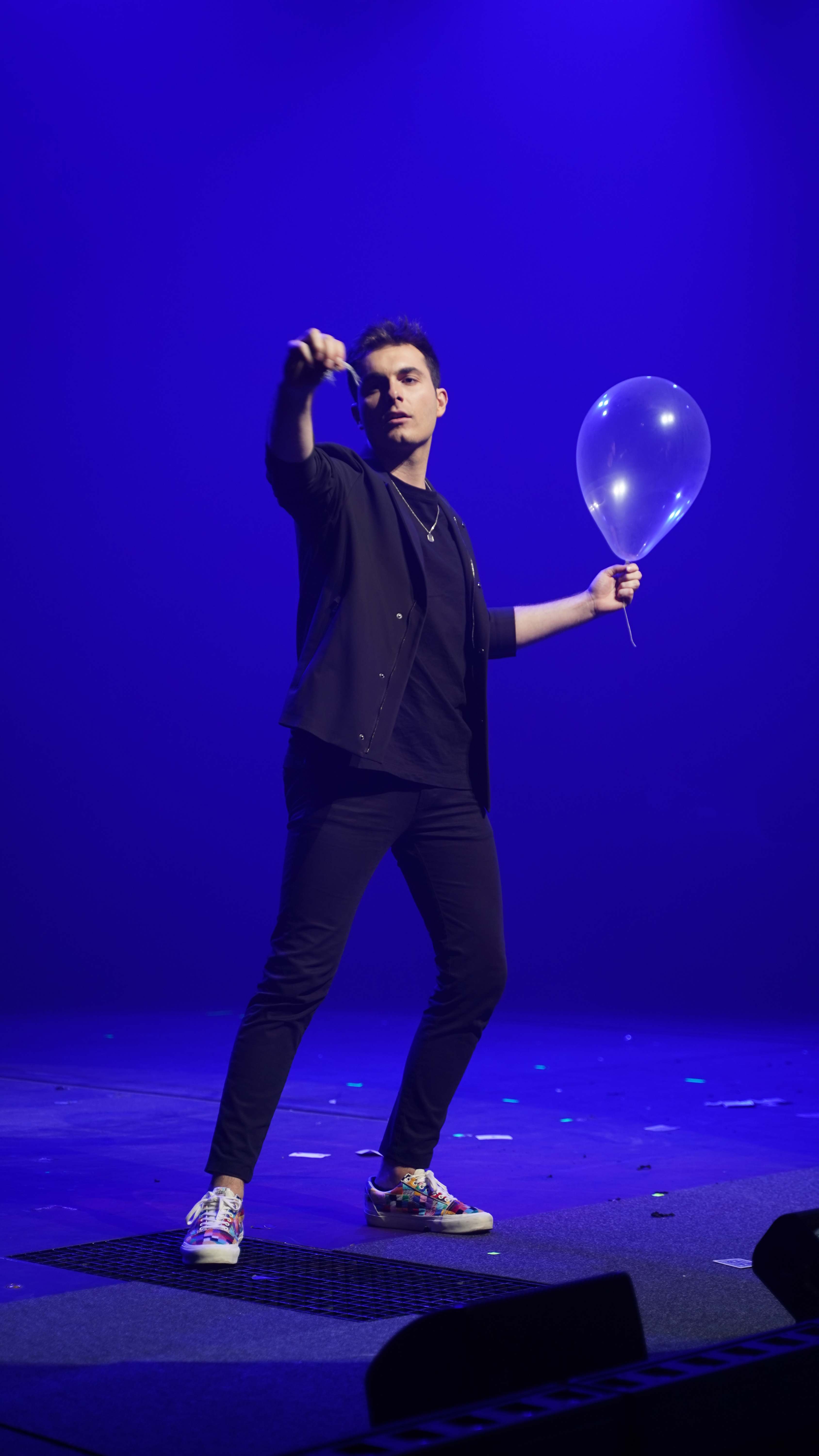 Mago de Magicbros sosteniendo un globo transparente bajo luz azul