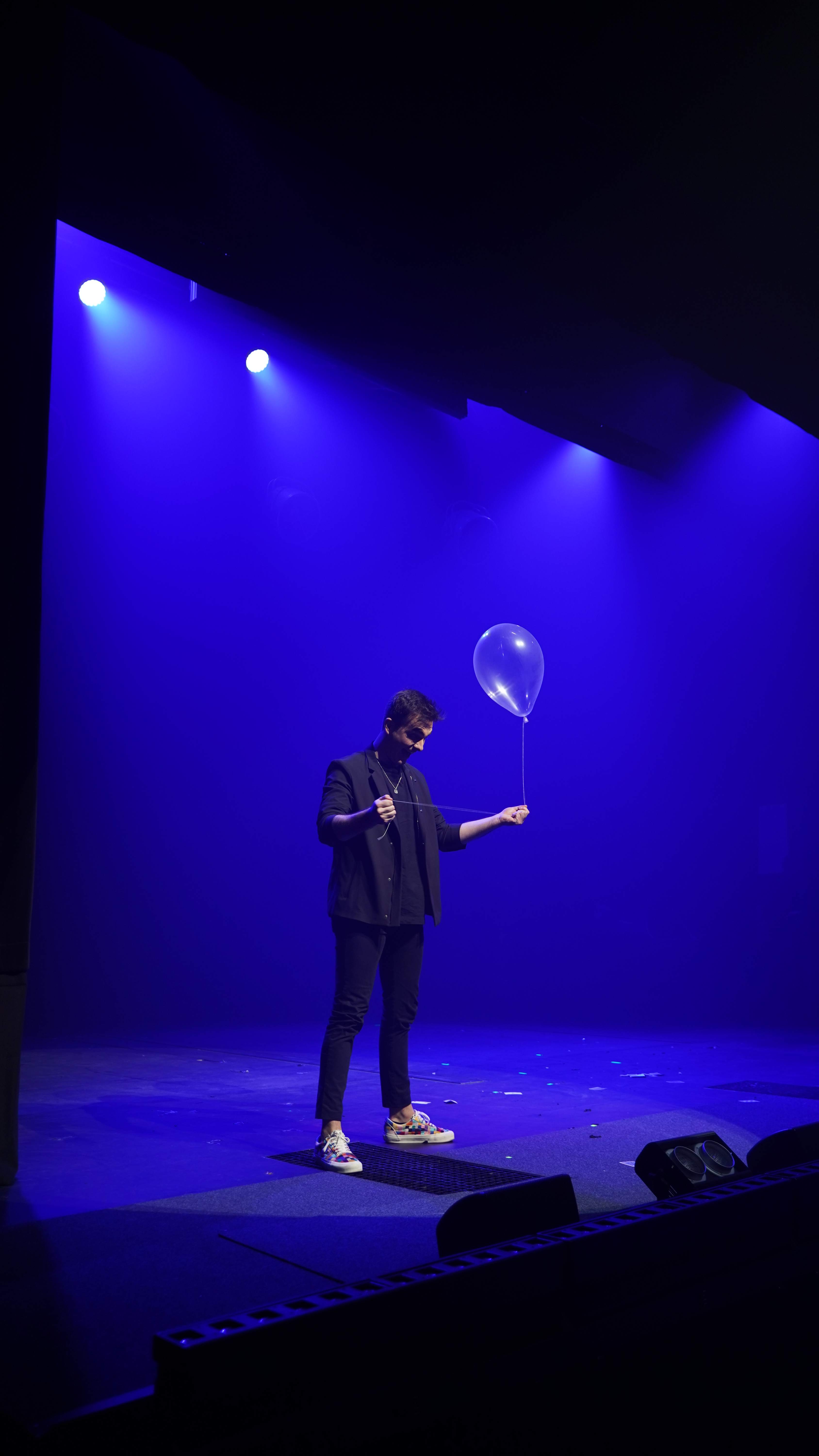Mago de Magicbros observando un globo transparente en escena azul